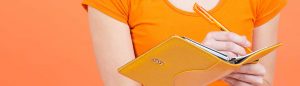 jeune femme habiller en orange tenant un journal pour prendre des rendez vous