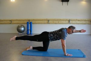 Votre coach sportif réalisant des figures de Pilates