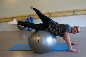 Votre coach sportif réalisant des figures de Pilates